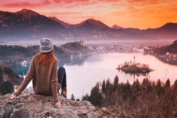 Foto auf Acrylglas Antireflex Traveling young woman looking on sunset on Bled Lake, Slovenia, Europe © nataliaderiabina