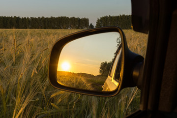 Reflection in the sunset mirror in the wheat field