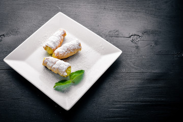 Pastry with Cream. On a wooden background. Top view. Free space for your text.