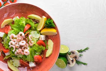 Shrimp Salad and Fresh Vegetables. On a wooden background. Top view. Free space for text