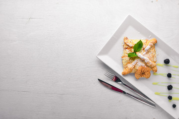 Strudel with apples and berries. On a wooden background. Top view. Free space for your text.