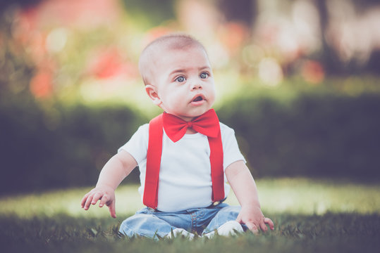 Vintage baby boy with red suspender and bow tie in outdoor