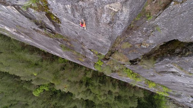 Drone Looking Down on Extreme Sports Athlete Climbing Massive Rock Mountain