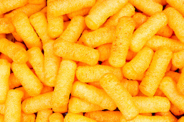Cheese puffs puff as background texture pattern wallpaper.
