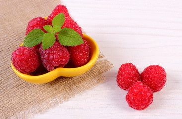 Fresh raspberries and lemon balm on white wooden board, healthy food and dessert