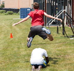 Leapfrogging your teammate on the grass behind the bleaches