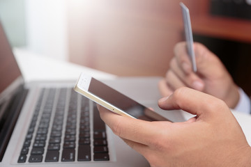 Side view of hands working with laptop and credit card,internet shopping concept.