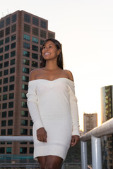 Elegant woman is smiling on the balcony of a building.