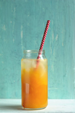 freshly-squeezed orange juice with ice on a pastel blue background.