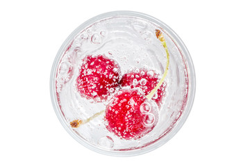 Top view of sweet shiny cherry in soda water with bubbles of carbon dioxide on white background.