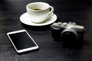 Coffee with camera and mobile phone on wood background.