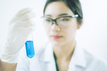 Fototapeta premium Young Asian scientist working in the lavatory with test tubes and other equipment to discover new drugs, products and methods of formulation