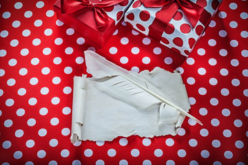 Fototapeta premium Present box vintage sheet of paper feather on polka-dot red fabr
