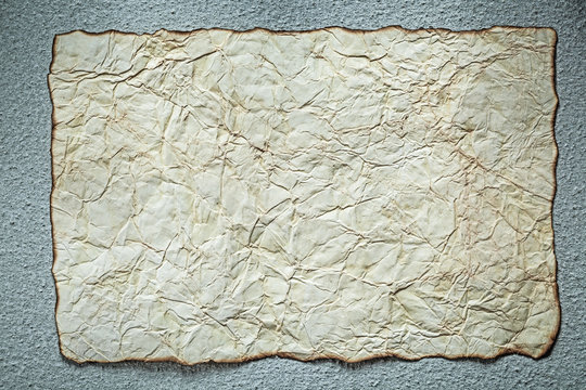 Vintage crumpled paper sheet on grey background top view