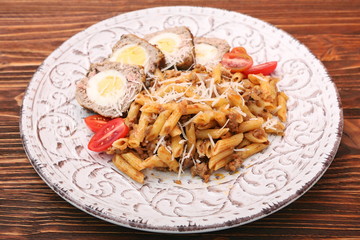 Boiled eggs in a layer of sausage meat wrapped with pasta