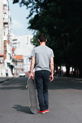 Street urban old school sport at summer. Unrecognizable hipster skateboarder and skate at the street. Journey for adult one man