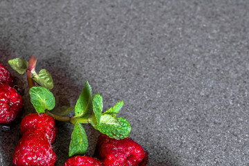 Frozen berry fruits, raspberry with ice and mint, on dark stone, from above