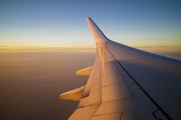 Obraz na płótnie Canvas Airplane wing at the sunset 