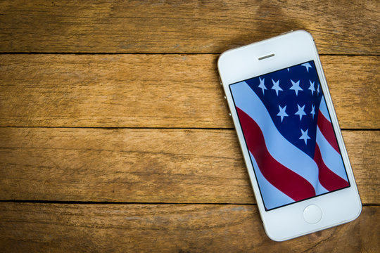 USA flag on mobile phone on wooden background for usa national day, 4th july, business, national day