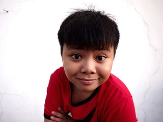 Young Asian boy wearing a red shirt
