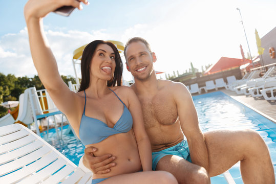 Cheerful couple making funny selfies on vacation