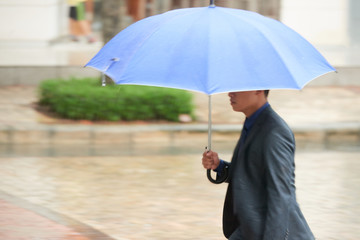 Asian Businessman Under Umbrella