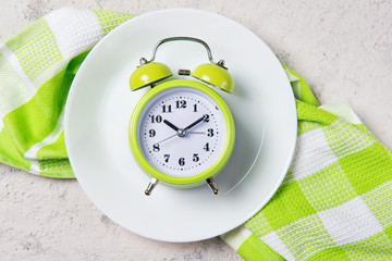 Alarm clock with bells on the plate, lunch time concept, top view with copy space