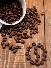 Overturned white cup with coffee beans