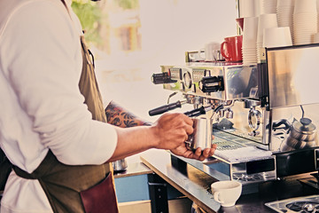 A man pouring coffee in a restaurant.