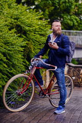 Obraz premium Casual bearded male in a park talks by smart phone.