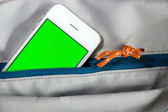 Smart phone in backpage pocket with green black screen for text or picture. Concecpt for advertising, business.