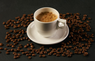 Coffee beans with coffee cup on a dark stone background. Coffee time