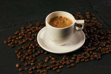 Coffee cup and coffee beans on a black stone table. Time for coffee