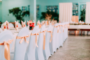 Decorative White Mantles And Colored Ribbons On Chairs At Festive Table