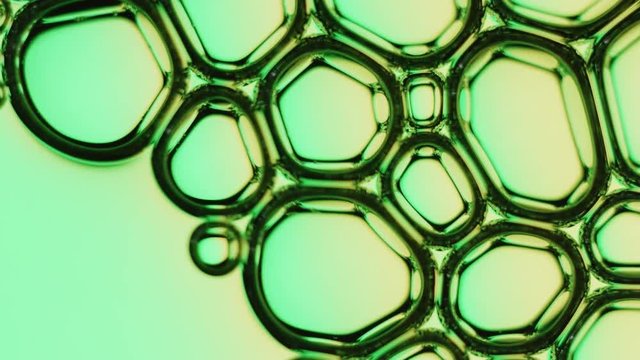 Air bubbles in liquid disappear on green and yellow background