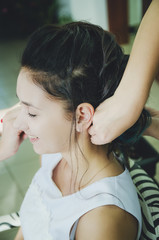 Naklejka premium A professional hairdresser makes a festive hairstyle for the girl. Close-up.