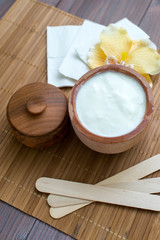 White substance in wooden cup with cinnamon and spices. For hair, face, spa.