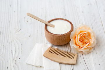 White substance in wooden cup with cinnamon and spices. For hair, face, spa.