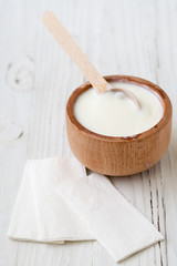White substance in wooden cup with cinnamon and spices. For hair, face, spa.