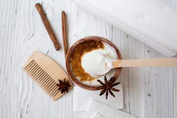 White substance in wooden cup with cinnamon and spices. For hair, face, spa.