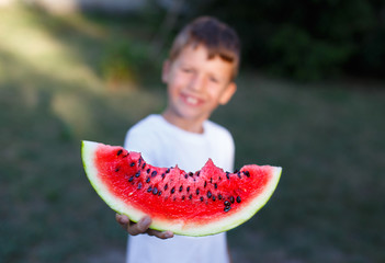 Little boy holding slice of watermelon depth of field