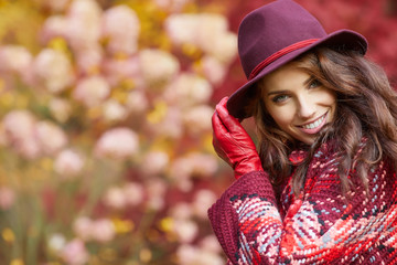 Portrait of an autumn woman over red and golden leaves