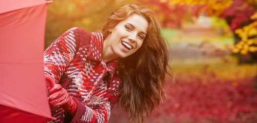 Portrait of an autumn woman over red and golden leaves