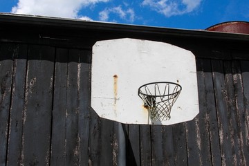 The basketball hoop on the wood background of the barn on a close up view.