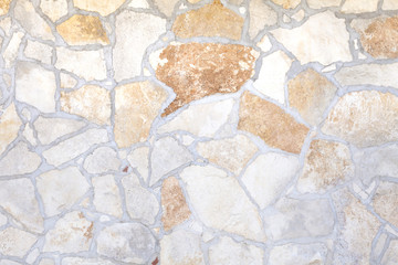 A wall made of stone, irregular but compact rocks. Background texture.
