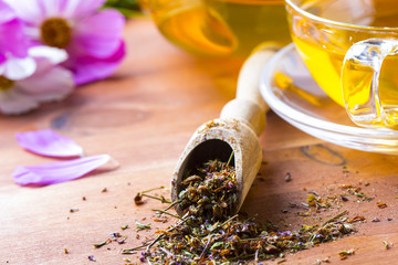 Tea herbs healing chamomile cup wooden background

