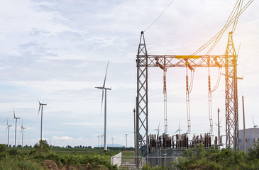 high voltage electrical power pylon substation  with wind turbines generating electricity for...