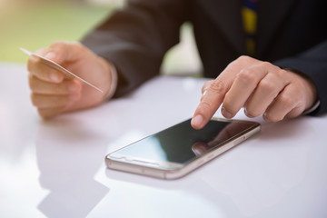 Women hold credit cards for online shopping. Internet purchase is popular because it is convenient, economical and secure.