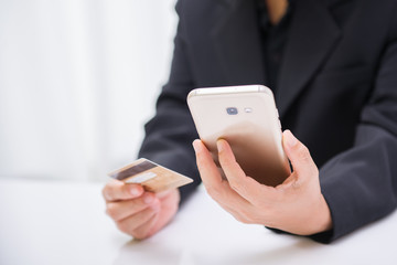 Women hold credit cards for online shopping. Internet purchase is popular because it is convenient, economical and secure.