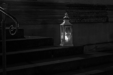 The old lantern with candle on stone step of stairs